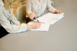 A woman filling out documents in an office, symbolizing the application process for the Codice Fiscale in Italy.