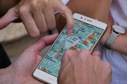 Семейство планира своето преместване в чужбина, разглеждайки карта, докато кучето им лежи до тях.