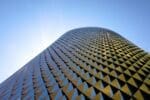 A modern, futuristic office building in District 2020, Dubai, illuminated by the sun.