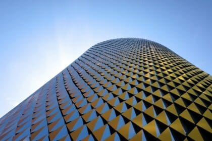 A modern, futuristic office building in District 2020, Dubai, illuminated by the sun.
