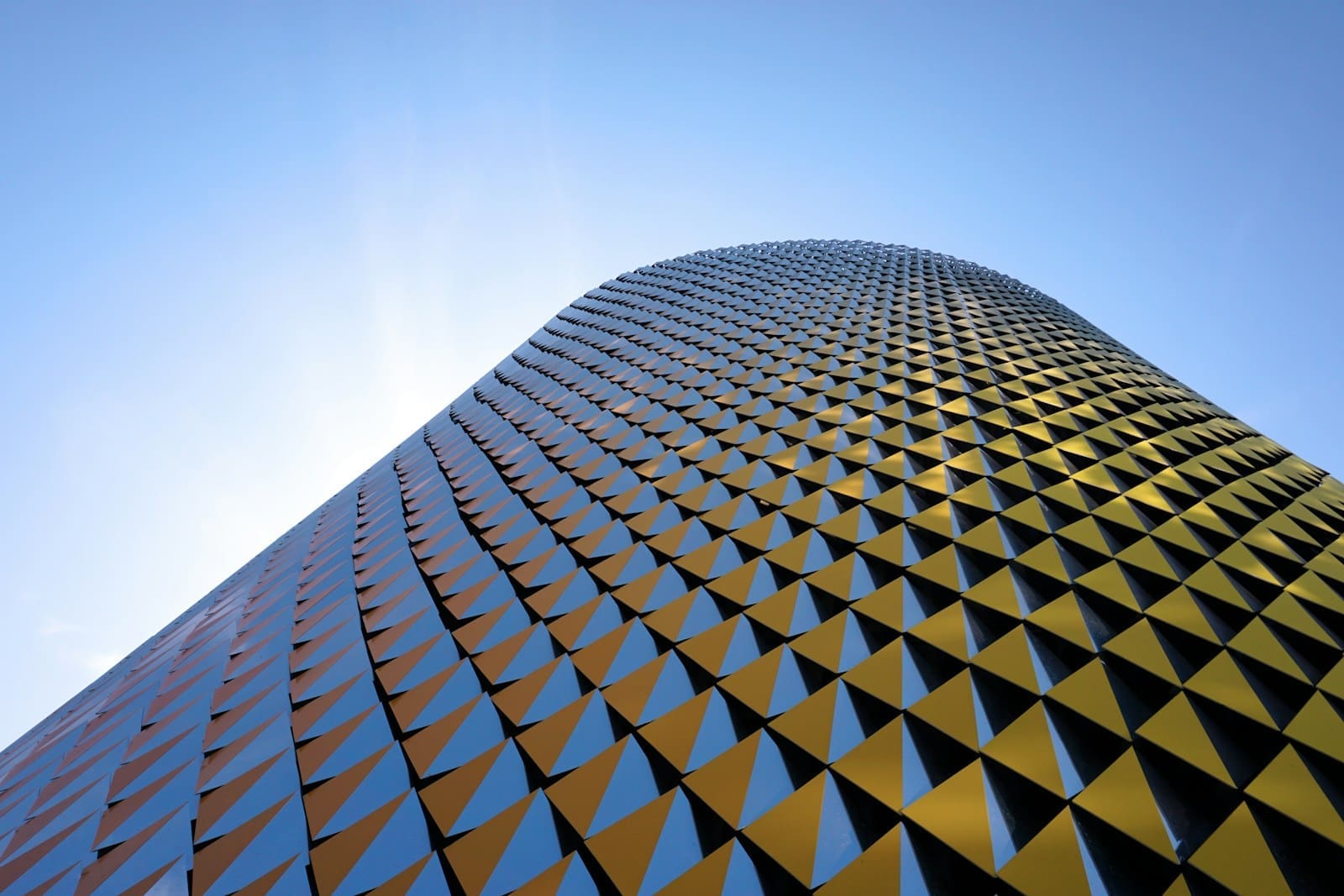 A modern, futuristic office building in District 2020, Dubai, illuminated by the sun.