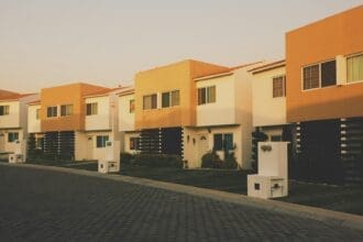 An investor looking over a modern villa community in Dubai against the sunset.