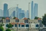 A modern neighborhood with luxury villas and townhouses in Dubai against the city skyline.