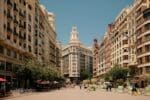 Sunny street with traditional Spanish buildings and balconies in Valencia, Spain.