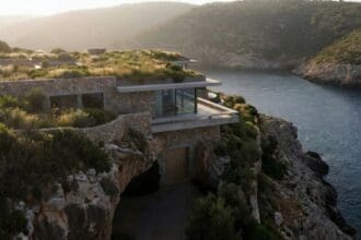 Modern luxury house dug into a cliff with a green roof and hidden entrance representing the Fortress Real Estate concept.